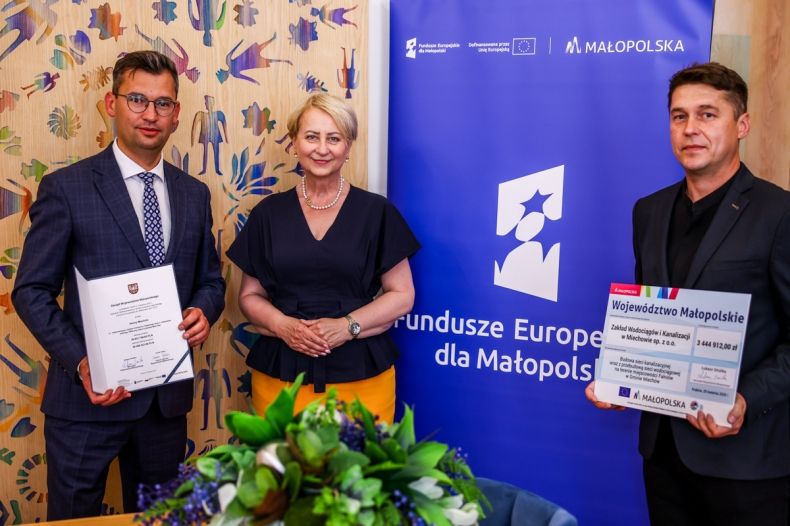Iwona Gibas z Zarządu Województwa Małopolskiego oraz przedstawiciele miasta i gminy Miechów prezentujący wspólnie przekazany uroczyście dokument i symboliczny czek