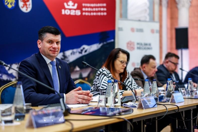 Cztery osoby siedzące przy stole konferencyjnym.