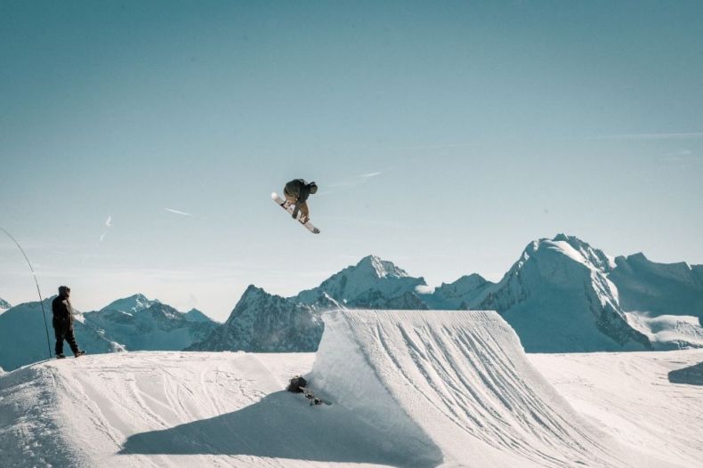 Snowbordzista w powietrzu. W tle ośnieżone szczyty Tatr.