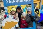 Dyrektor Kancelarii Zarządu Paulina Surman wraz z dziećmi pozują do zdjęcia, trzymając ramkę eventową z logo Małopolski