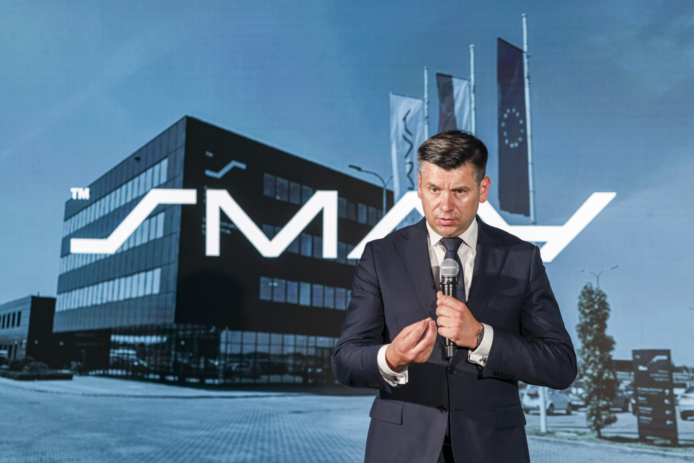 Marszałek Łukasz Smółka stoi z mikrofonem.