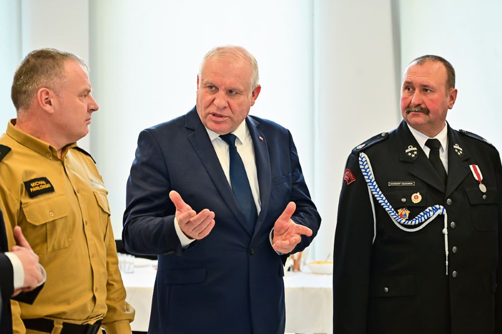 Wicemarszałek Ryszard Pagacz stoi ze strażakami.