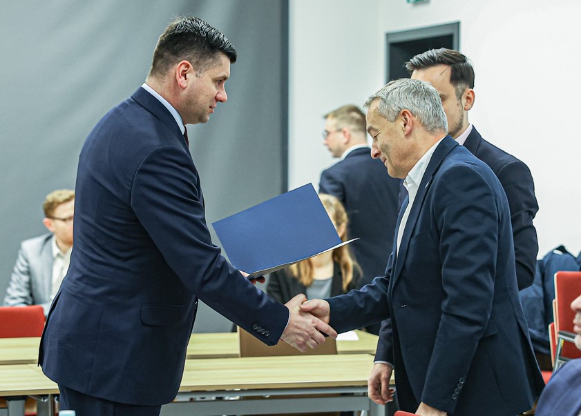 Marszałek Łukasz Smółka podaje rękę mężczyźnie.