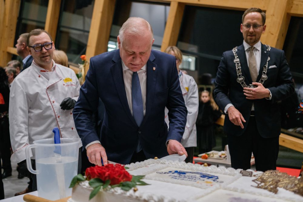Wicemarszałek Ryszard Pagacz kroi tort.