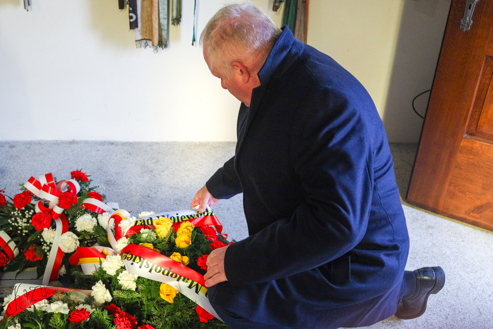 Wicemarszałek Ryszard Pagacz klęczy przed grobem.