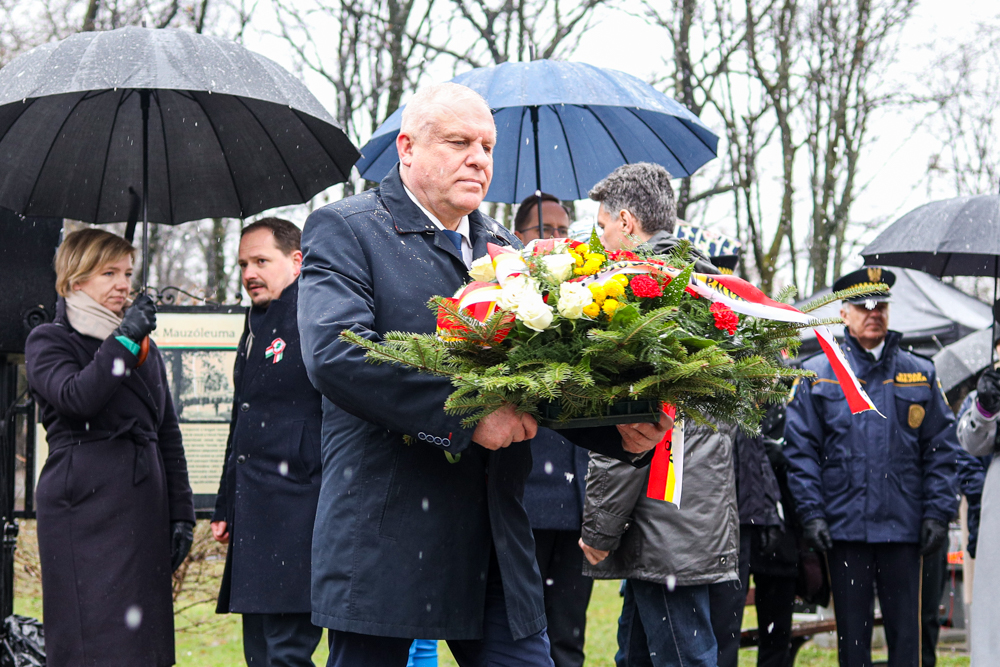 Wicemarszałek Ryszard Pagacz niesie kwiaty.