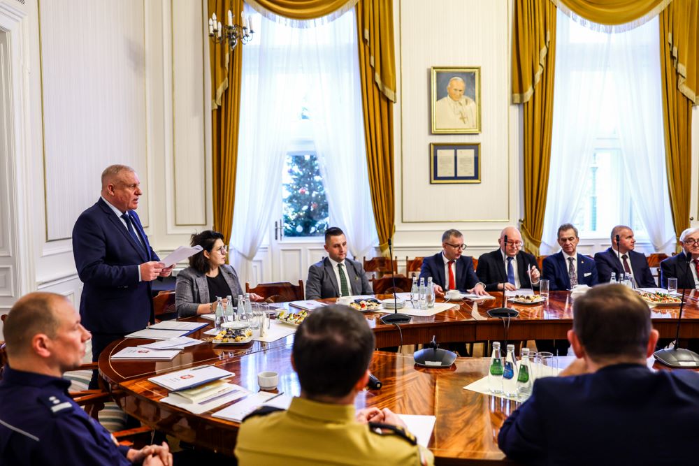 Wicemarszałek Ryszard Pagacz stoi przy stole.