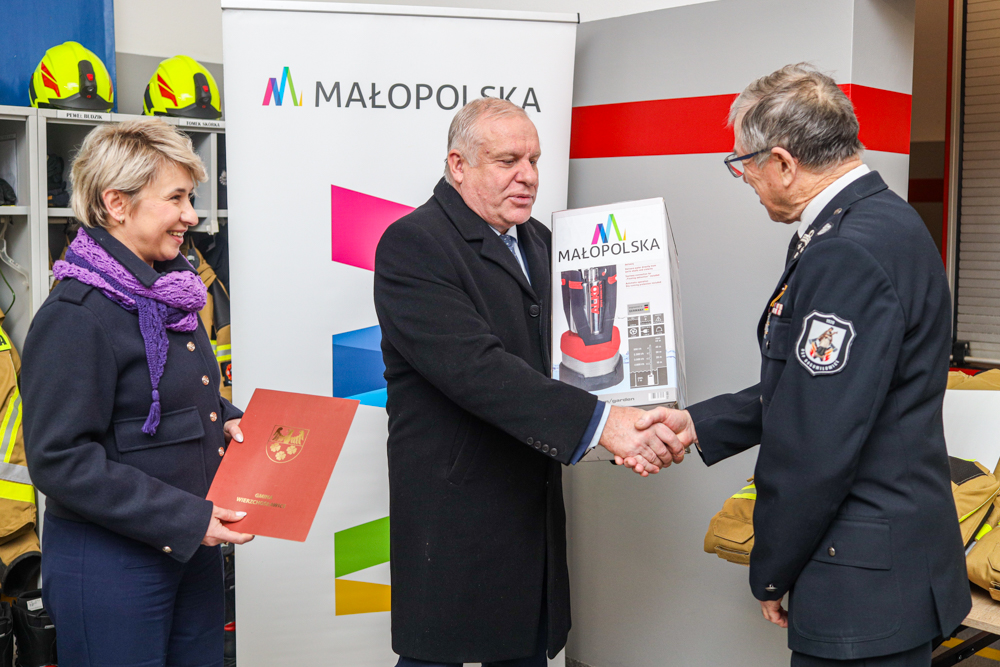 Wicemarszałek Ryszard Pagacz podaje rękę strażakowi.