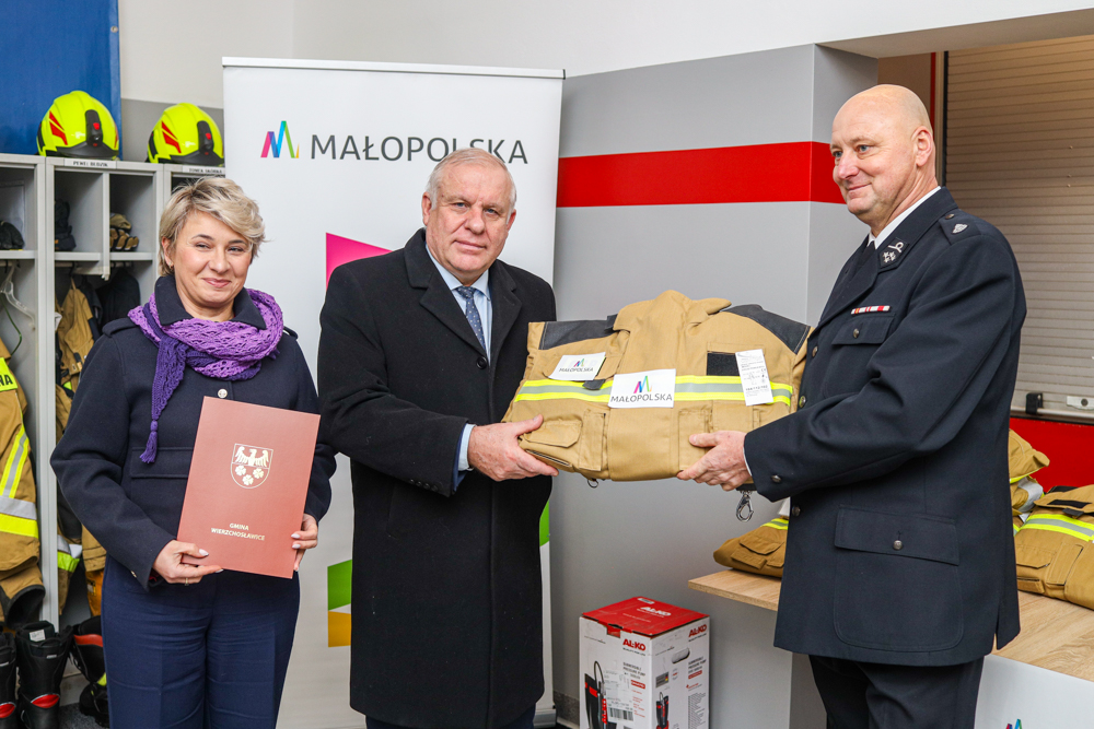 Wicemarszałek Ryszard Pagacz przekazuje mundury strażakowi.