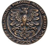 Zdjęcie brązowego Medalu Honorowego za Zasługi dla Województwa Małopolskiego. Medal ma kształt koła. Na licu (awersie) widnieje wizerunek Orła Białego – godło z herbu Województwa Małopolskiego.