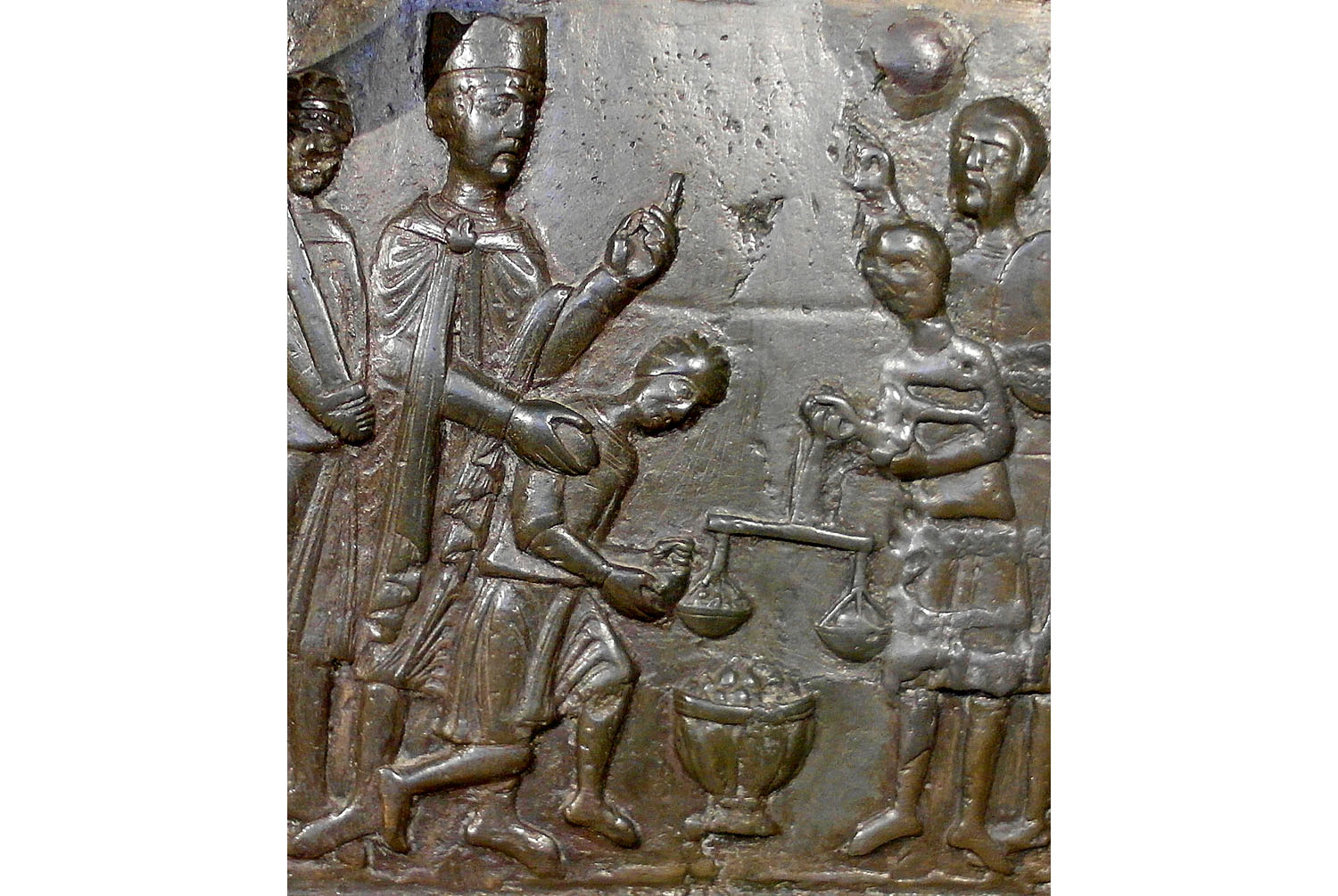Fragment jednej z kwater Drzwi Gnieźnieńskich, przedstawiających scenę wykupienia zwłok św. Wojciecha przez księcia Bolesława. Drzwi Gnieźnieńskie to jeden z najcenniejszych zabytków polskiej kultury. Zostały wykonane w XII wieku i przedstawiają życiorys patrona Polski. Szesnasta kwatera ukazuje Bolesława Chrobrego, który wraz z towarzyszami uczestniczy w wykupie zwłok Wojciecha. Po drugiej stronie widać Prusów, w tym skarbnika, który nakłada wykup na szale wagi